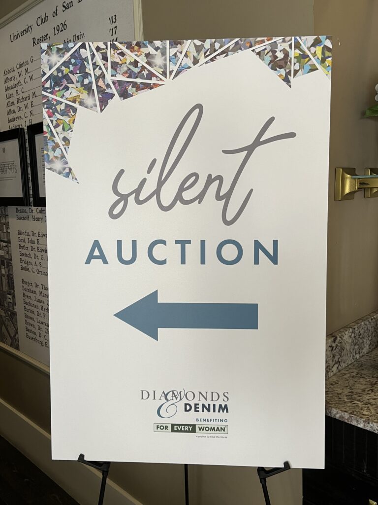 Silent auction sign with Diamonds & Denim branding at San Diego women’s fundraiser event