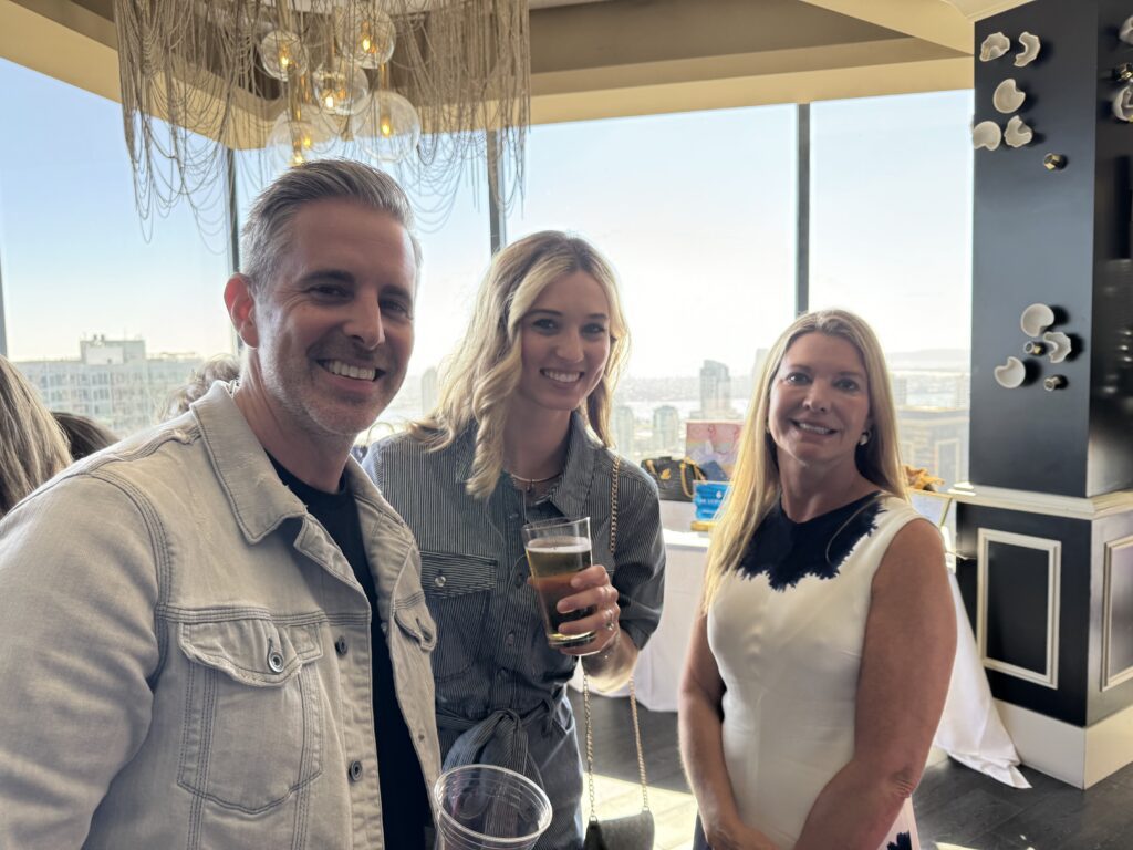 Smiling guests enjoying drinks at Diamonds & Denim 2025 fundraiser at the University Club San Diego