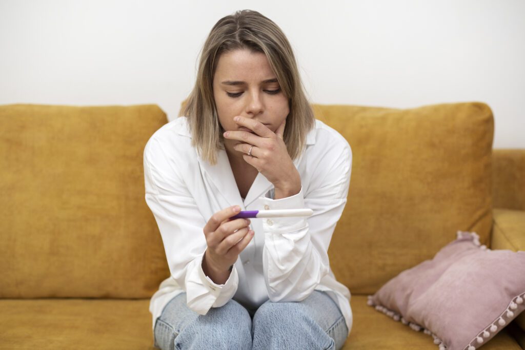 A woman looking at a pregnancy test wondering if she is pregnant.