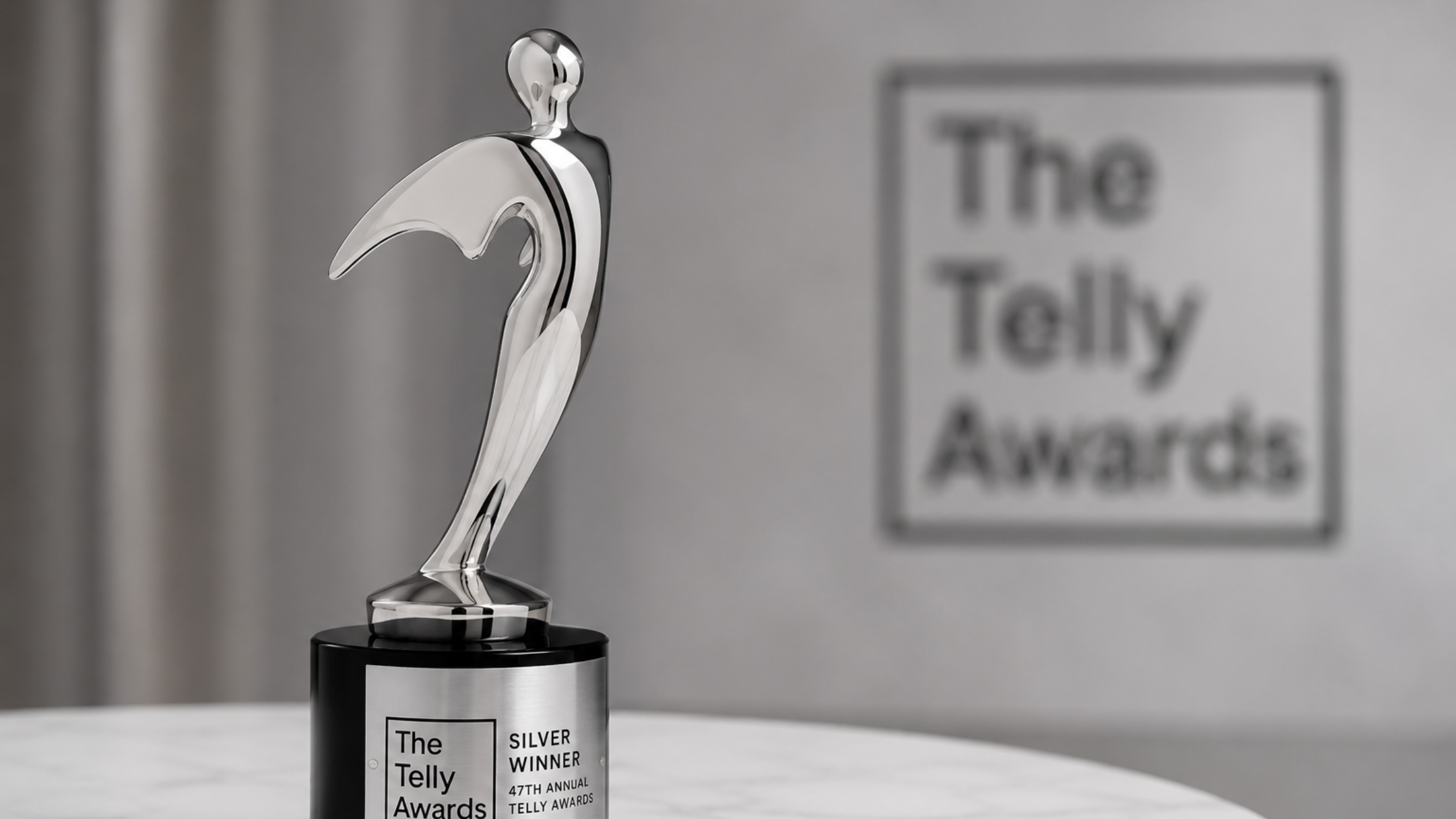 Silver Telly Award trophy recognizing excellence in nonprofit video storytelling, displayed on a marble table with The Telly Awards logo in the background.