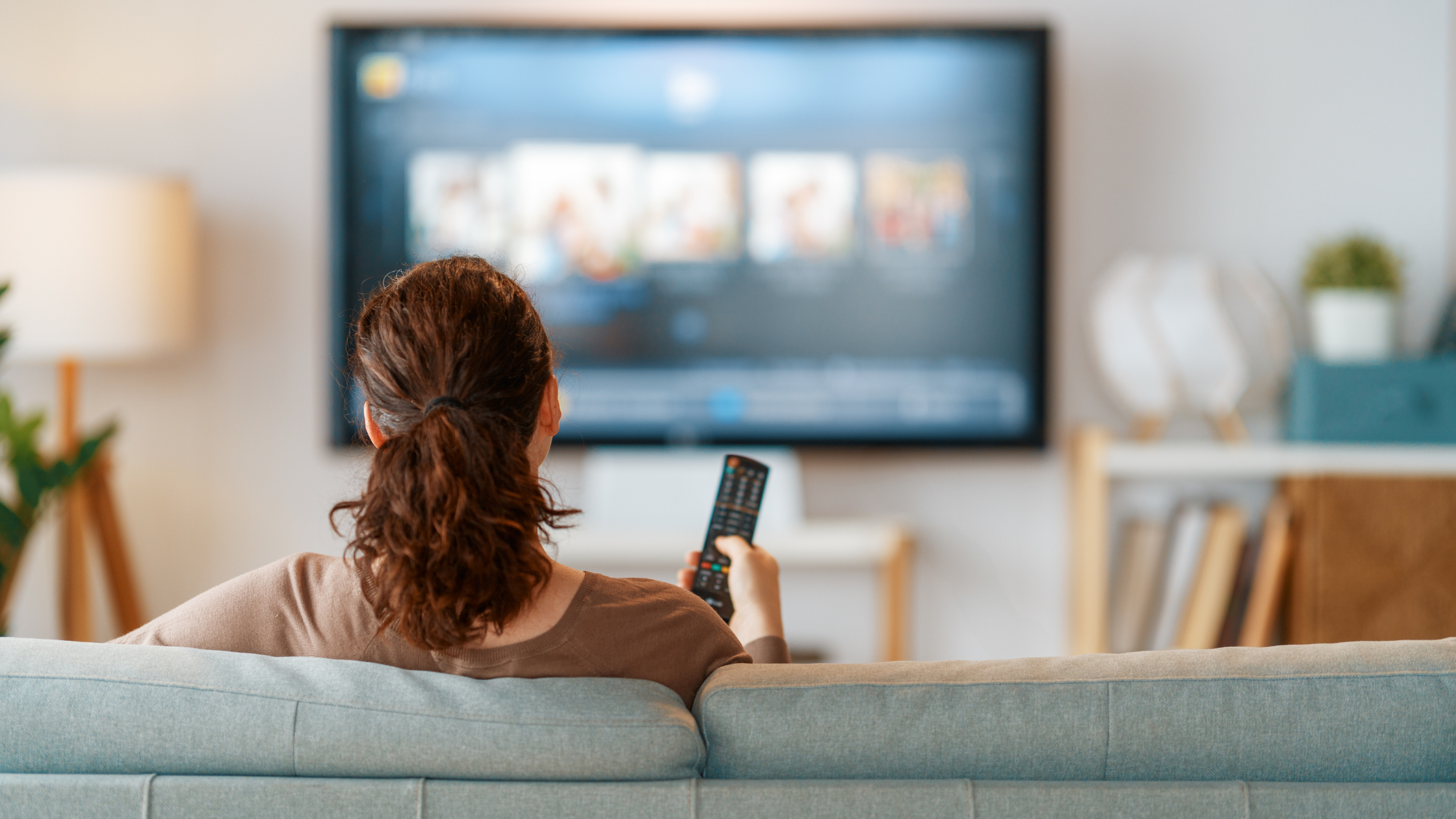 Woman watching television at home, representing how TV portrays women’s health.