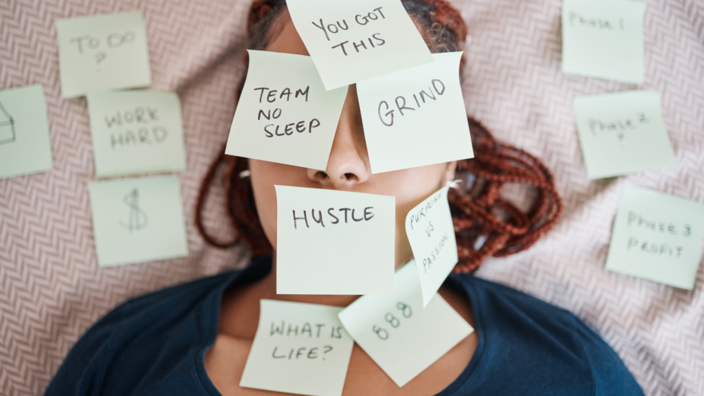 Woman lying down with sticky notes covering her face, representing stress, overwhelm, and burnout.